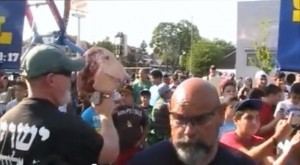 Ruben Israel and an associate carry a pig's head on a stick at the Dearborn Islamic festival.