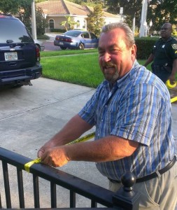 John Barros helps police tape off the abortion facility's driveway.