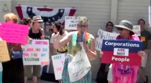 A woman holds up a hanger during a protest against Hobby Lobby in Burbank, California.